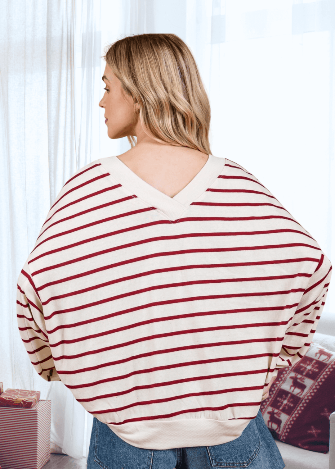 Spread holiday cheer in this oversized sweatshirt featuring a cheerful Merry Christmas graphic against cream and crimson stripes. The double V-neck and drop shoulder design create an effortlessly relaxed silhouette that's perfect for cozy gatherings or casual days at home.  Made in USA