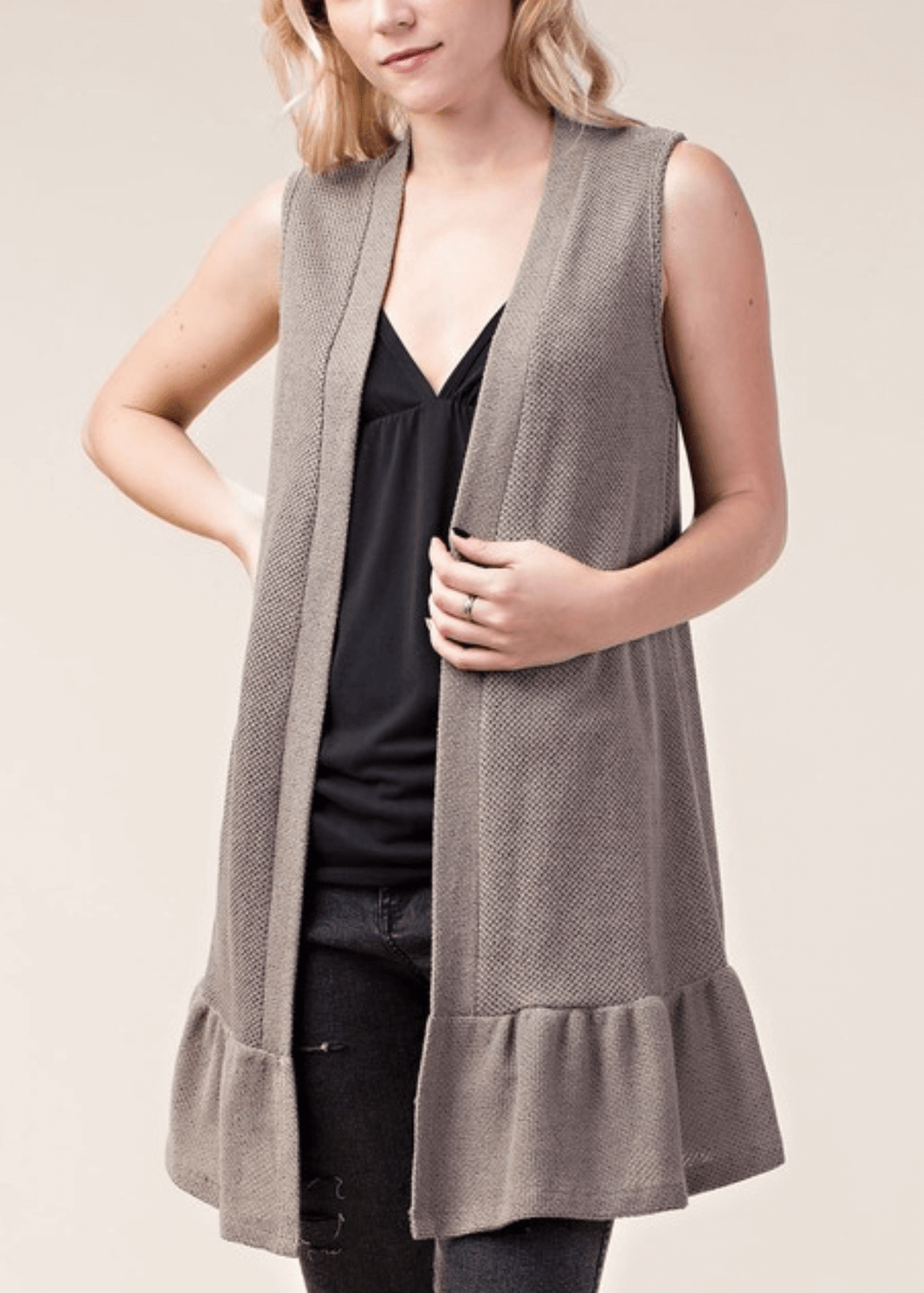 The Monica Open Front Ruffled Knit Accent Vest is your go-to layering piece for effortless style. This sleeveless cardigan vest features a charming flounce ruffle hem that adds movement and dimension to any outfit. 