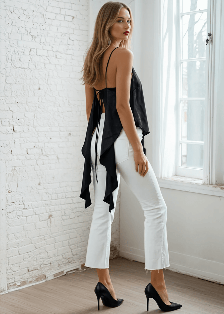 Embrace effortless edge with this sleek black satin tank. Adjustable shoulder-to-back ties let you customize the fit while the open back and lace-up detail deliver undeniable allure. A ruffled, asymmetrical hem adds movement and intrigue to every wear.