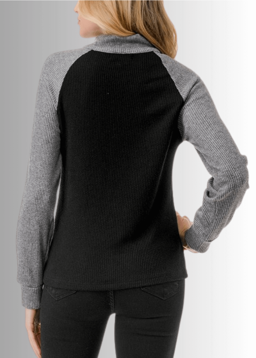 This Paige Color Block Zip Detail Top offers a sleek, semi-fitted silhouette crafted from medium-weight fabric, perfect for layering or standalone wear. Featuring a stylish quarter zip front and a modern black and gray color block design, it combines comfort with contemporary appeal. Made in the USA