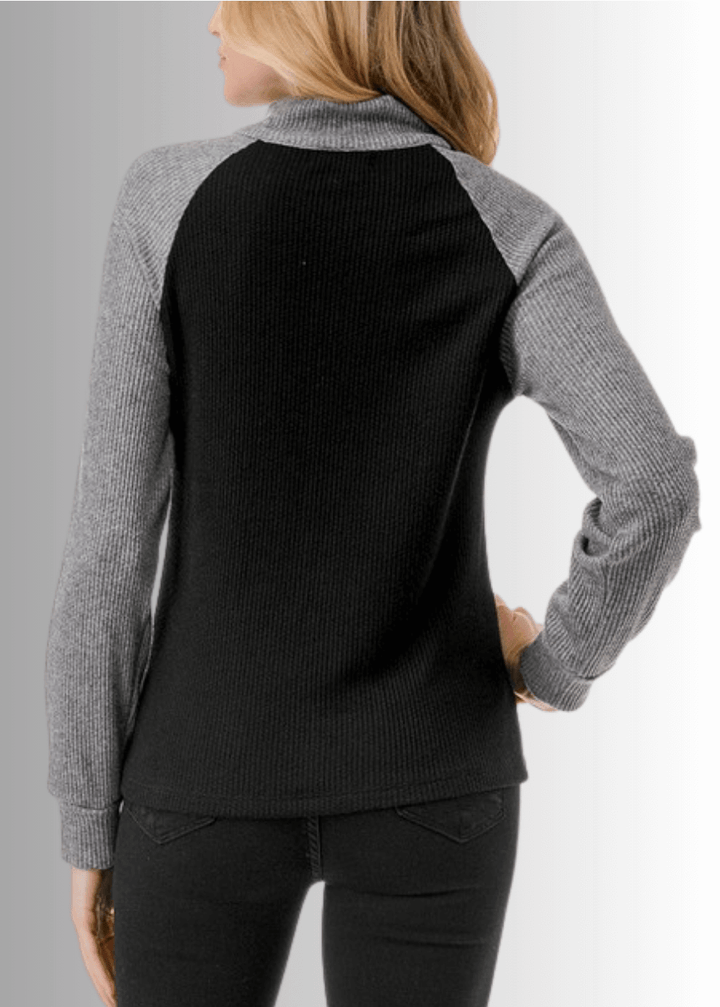 This Paige Color Block Zip Detail Top offers a sleek, semi-fitted silhouette crafted from medium-weight fabric, perfect for layering or standalone wear. Featuring a stylish quarter zip front and a modern black and gray color block design, it combines comfort with contemporary appeal. Made in the USA