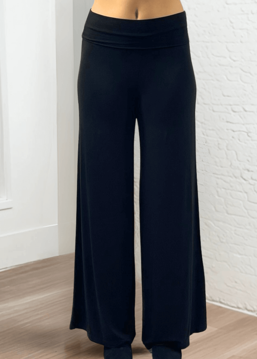 Experience ultimate comfort and style with these Soft Rayon Jersey Palazzo Pants in Solid Black, crafted in the USA. Featuring a flattering fold-over waist and a wide-leg silhouette, they offer a relaxed yet chic look. Made from a stretchy blend of rayon and spandex, these pants move with you while maintaining their softness.
