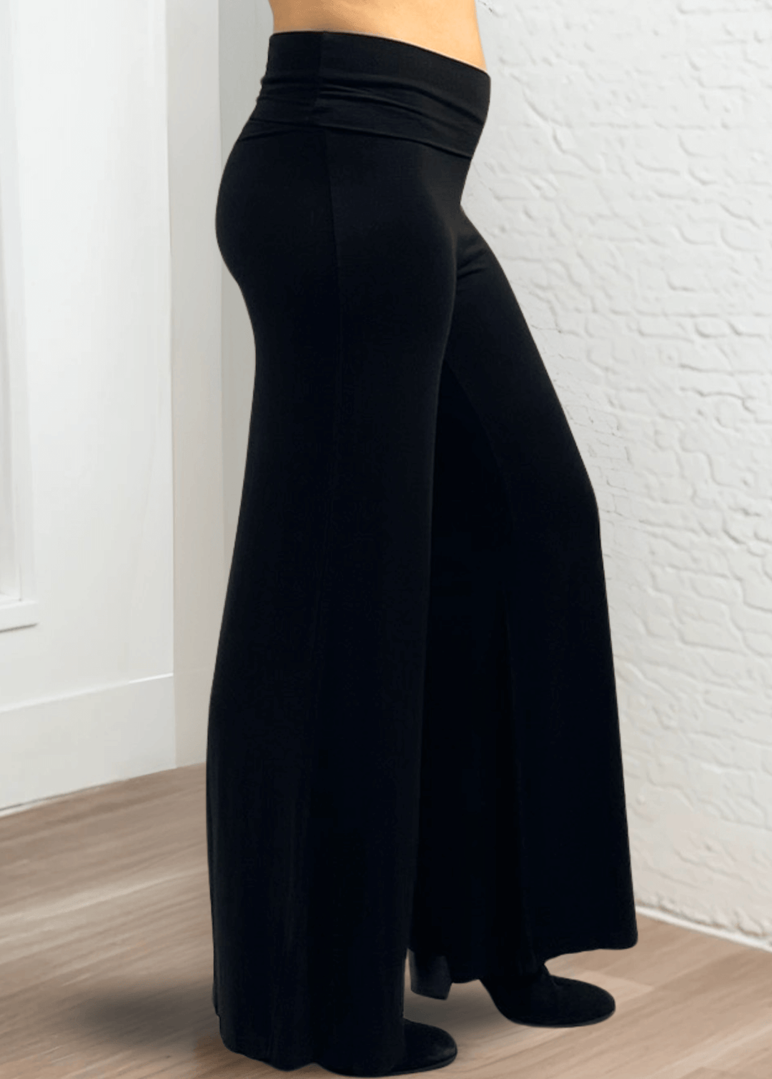 Experience ultimate comfort and style with these Soft Rayon Jersey Palazzo Pants in Solid Black, crafted in the USA. Featuring a flattering fold-over waist and a wide-leg silhouette, they offer a relaxed yet chic look. Made from a stretchy blend of rayon and spandex, these pants move with you while maintaining their softness.