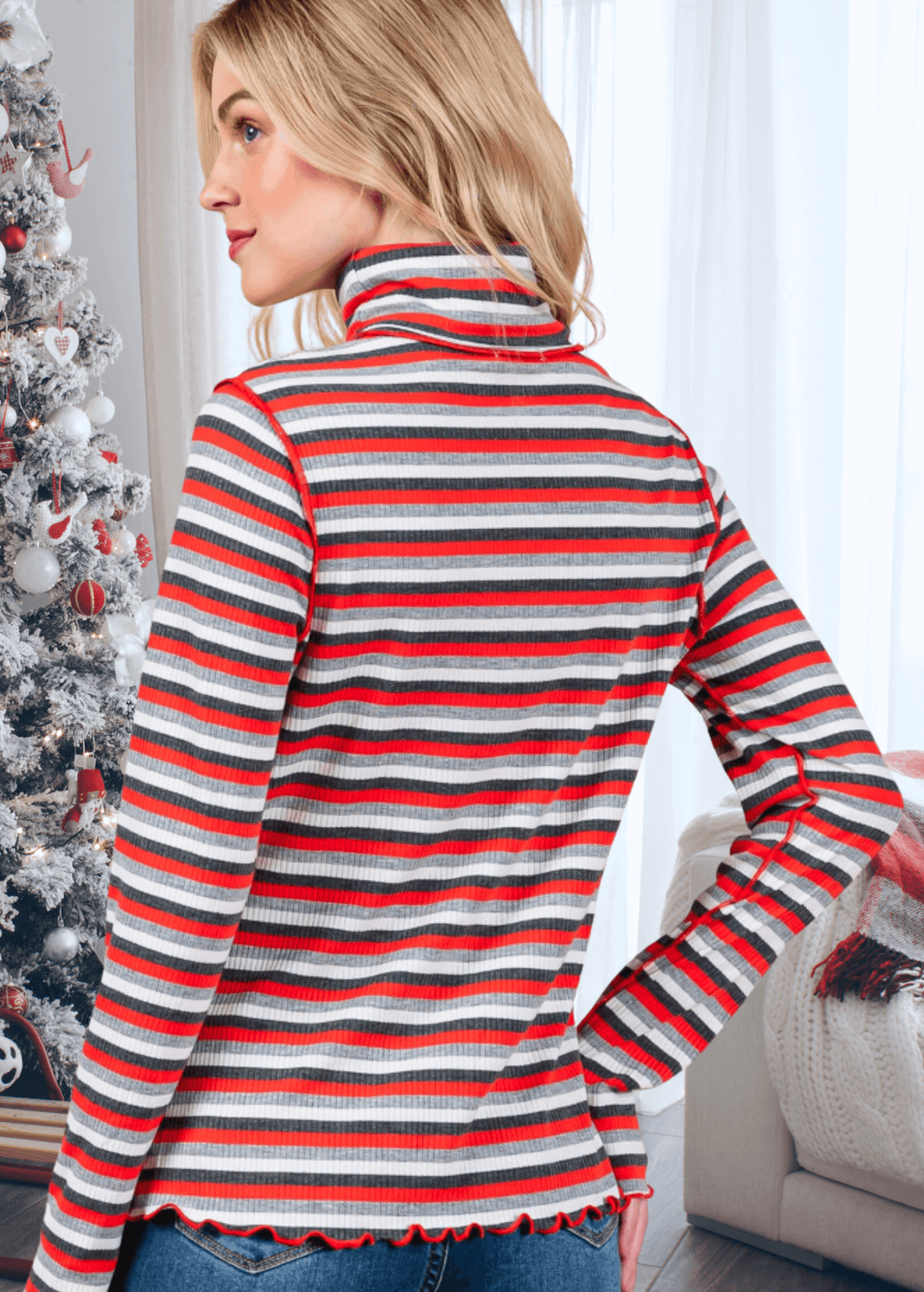 Bring holiday cheer to your wardrobe with this whimsical reindeer turtleneck! Featuring a delightful graphic paired with bold stripes in festive red or green, this lightweight ribbed knit top keeps things fun and cozy. The mock turtleneck and semi-fitted cut offer a flattering everyday look, while playful lettuce merrow stitching at the cuffs and hem adds personality