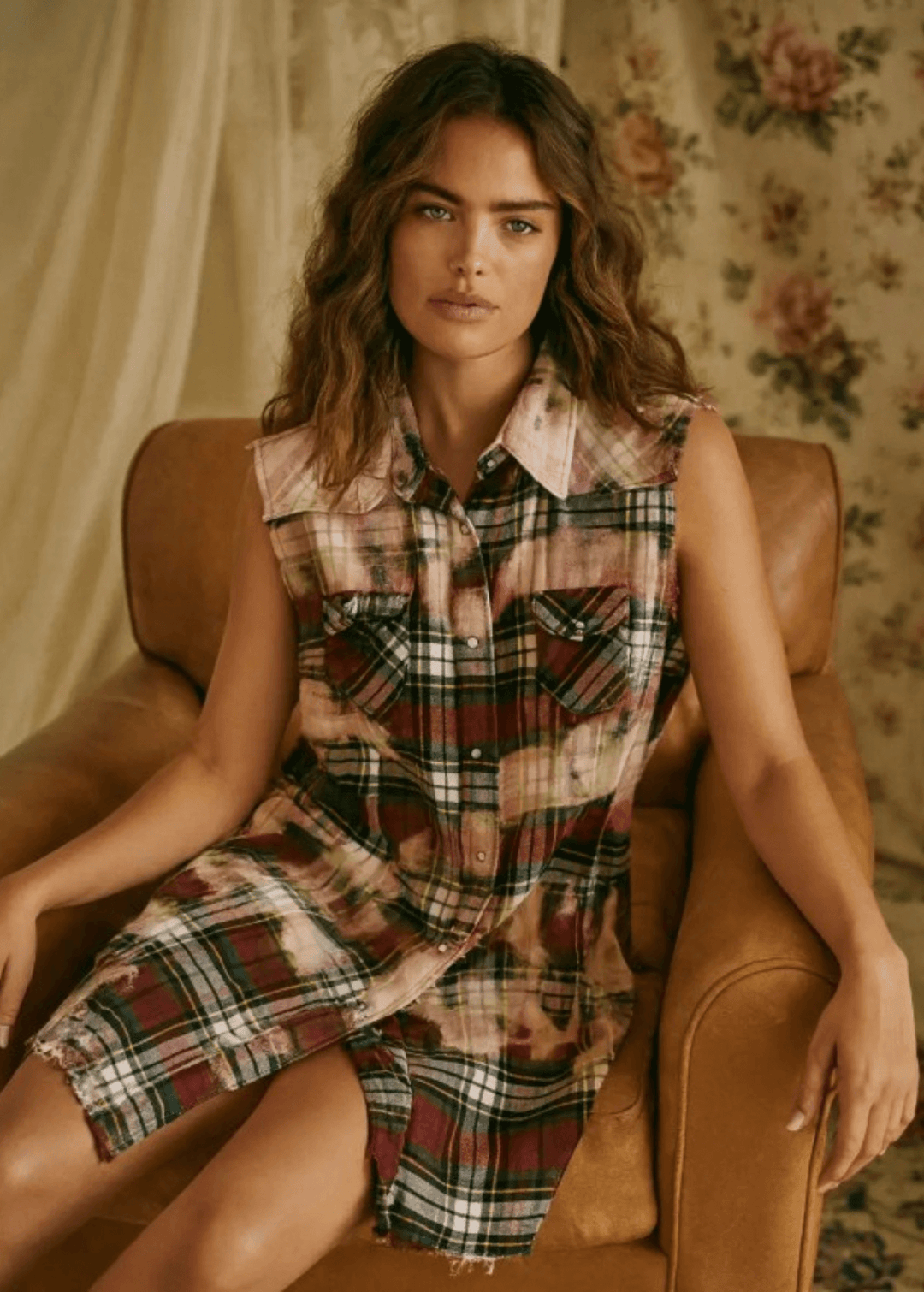 Meet The Sedona Sunset Sleeveless Plaid Flannel Tunic - a sleeveless, boho-chic essential designed for effortless layering and laid-back luxury. Crafted in Los Angeles from ultra-soft, vintage-washed plaid, this one-of-a-kind piece features hand-bleached details, raw frayed edges, and classic chest pockets for a relaxed yet elevated vibe. Its tunic length makes it versatile enough to wear open over denim shorts or buttoned up as a dress.