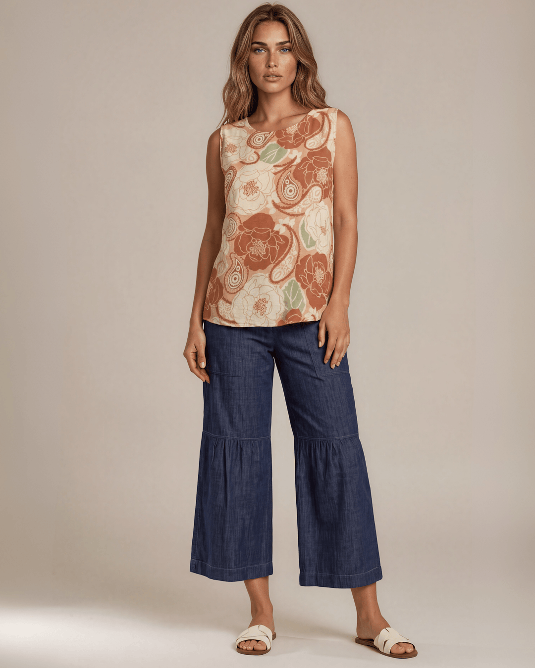 Sleeveless boat neck top in a rust floral paisley print. Hammered satin look, Rayon Linen Blend Fabric, longer in back. Made in USA.