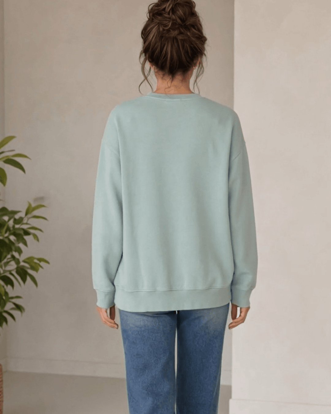 Made in USA Abstract Art Christmas Tree crew neck sweatshirt in sage green with a painterly abstract art Christmas tree graphic, back view with a plain back on female model with jeans