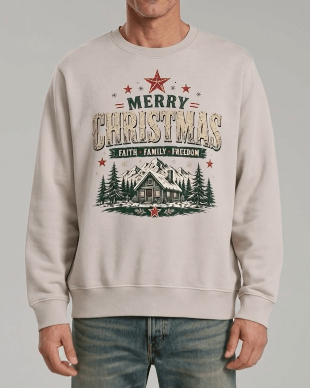 Made in USA Faith Family Freedom Christmas Cabin crew neck sweatshirt in beige with a Merry Christmas Faith Family Freedom log cabin graphic, front view on male model with jeans