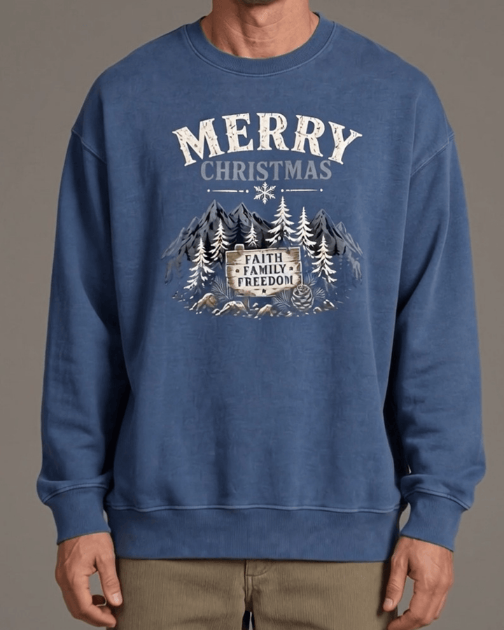 Made in USA Merry Christmas Faith Family Freedom crew neck sweatshirt in denim blue with a Merry Christmas Faith Family Freedom mountain graphic, close-up front view of the graphic on male model with khaki pants