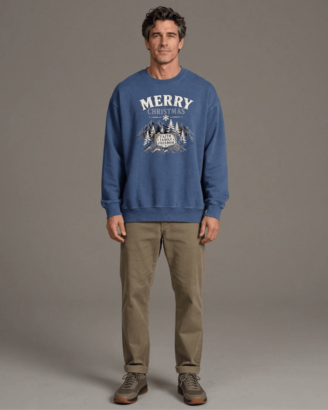 Made in USA Merry Christmas Faith Family Freedom crew neck sweatshirt in denim blue with a Merry Christmas Faith Family Freedom mountain graphic, front full-length view on male model with khaki pants