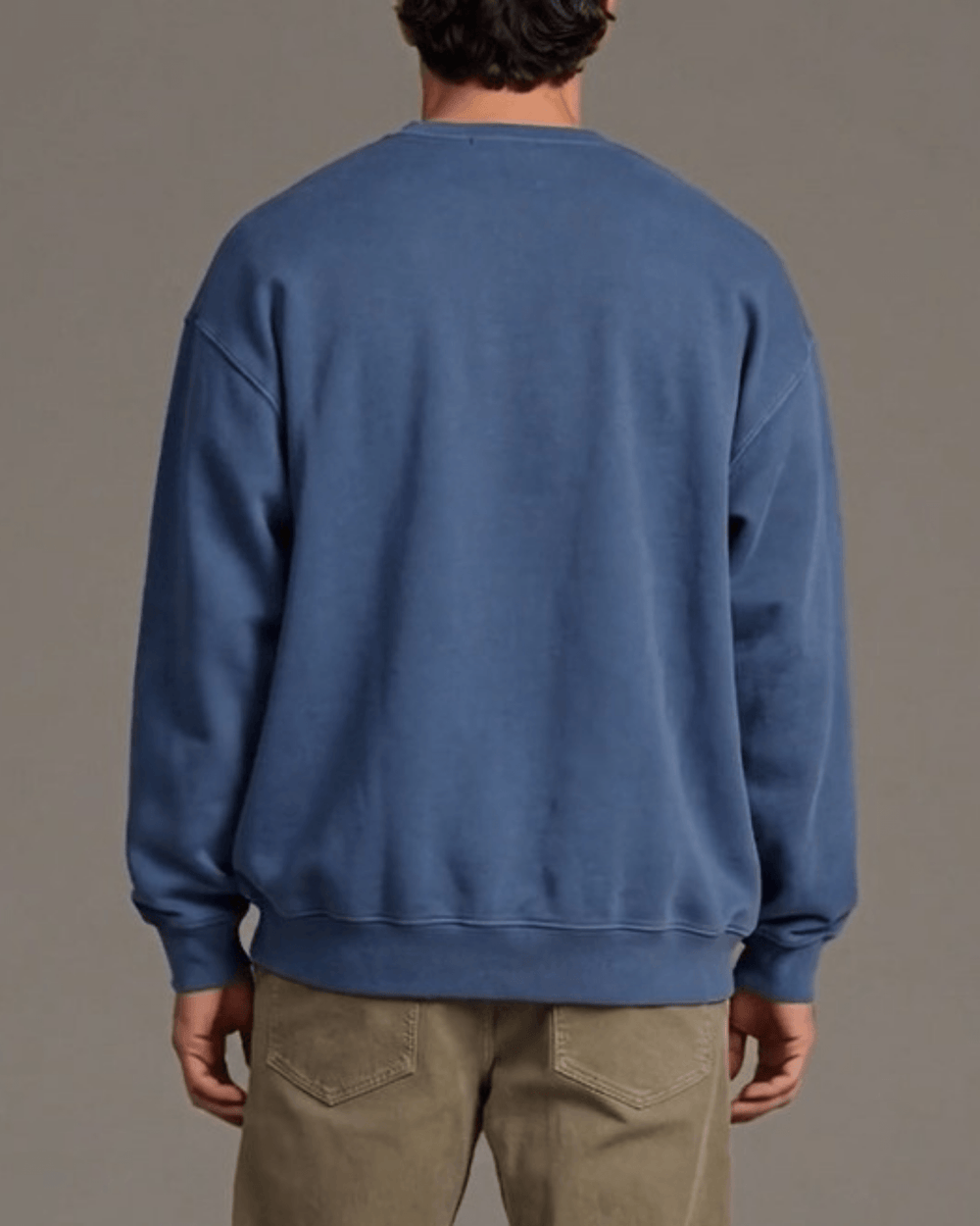 Made in USA Merry Christmas Faith Family Freedom crew neck sweatshirt in denim blue with a Merry Christmas Faith Family Freedom mountain graphic, back view with a plain back on male model with khaki pants