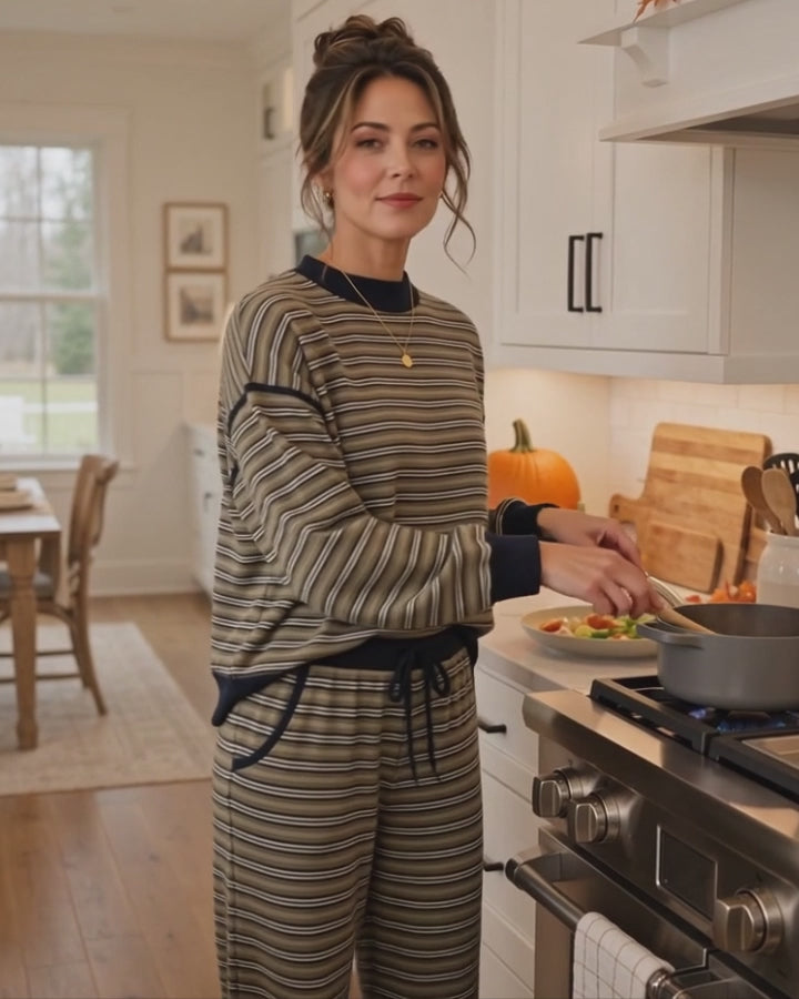 Model wearing the Striking Stripes olive and navy striped mock neck top with matching ankle length drawstring pants while cooking in a kitchen, Made in USA