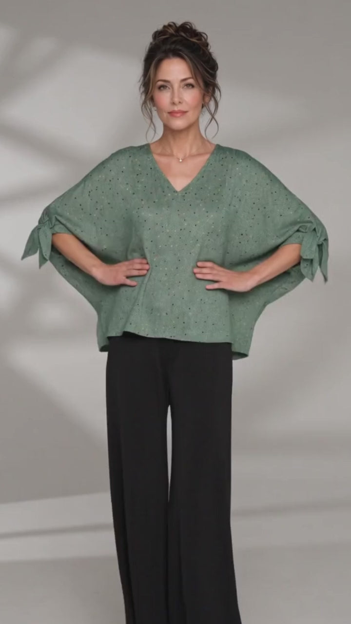 Made in USA. Green confetti dot chevron blouse with a V-neck, dolman sleeves and adjustable cuff ties. Lightweight woven fabric with a loose, flowing fit.