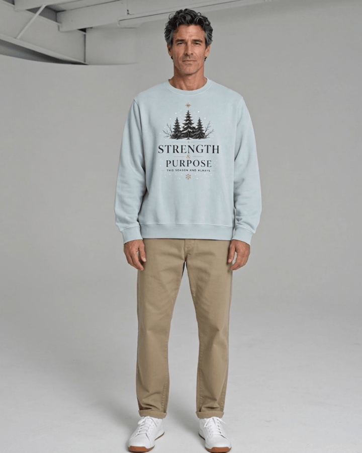 Made in USA Strength and Purpose Holiday Design crew neck sweatshirt in light blue with a Strength and Purpose holiday graphic with navy evergreens and a gold star, front full-length view on male model with khaki pants