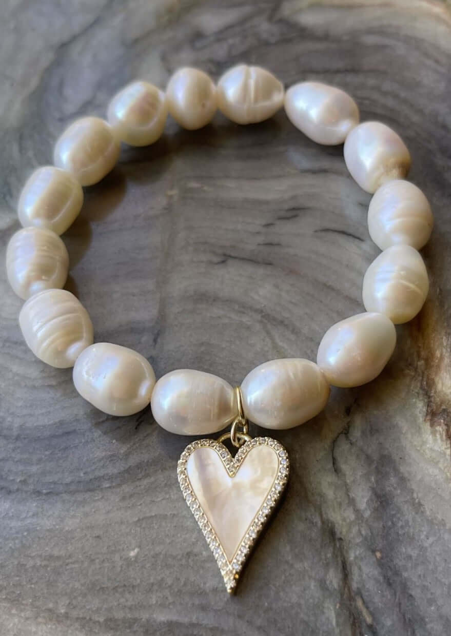 Hand Made in Texas USA This beautiful hand made Freshwater Pearl stretch bracelet has a handmade heart charm with a freshwater pearl veneer surface.