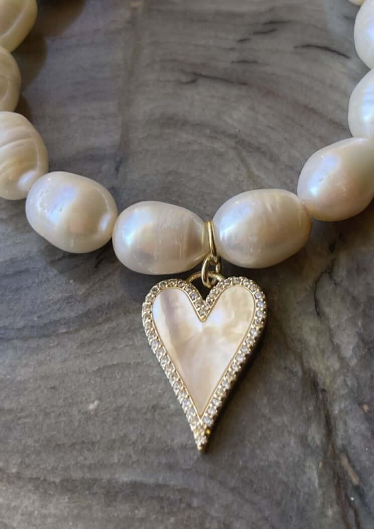 Hand Made in Texas USA This beautiful hand made Freshwater Pearl stretch bracelet has a handmade heart charm with a freshwater pearl veneer surface.